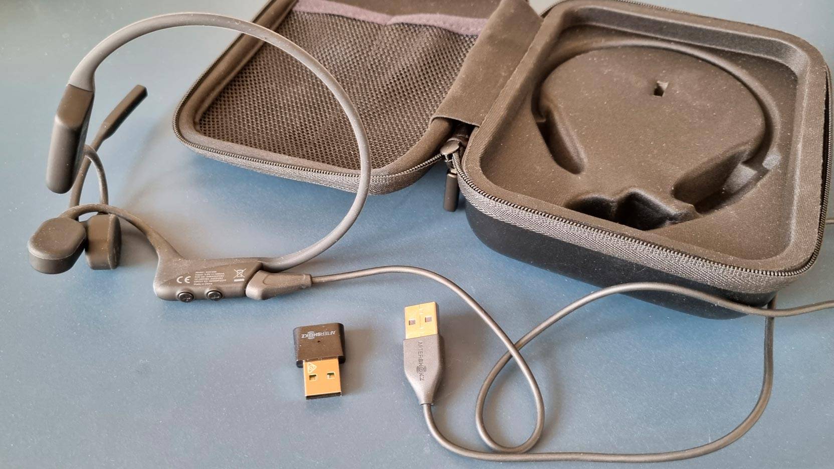 Billede fra test af bone conducting headset AfterShokz OpenComm UC taske, ladekabel og Bluetooth dongle